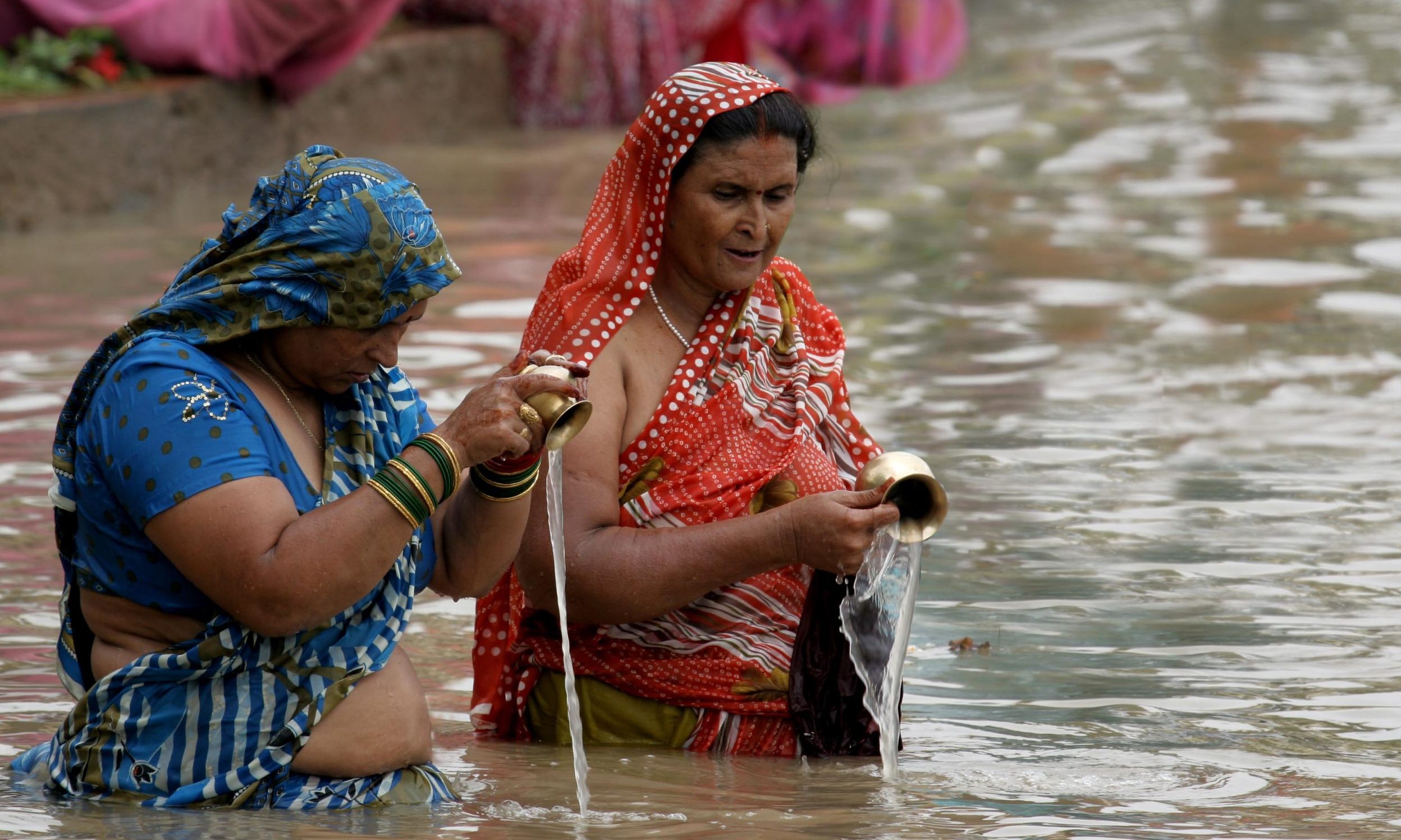 Hindu women offering water of the Ganges River to the Sun God