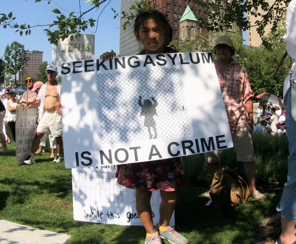 An activist at a rally against family separation in Cleveland, Ohio, holds a sign stating “Seeking Asylum in Not a Crime”
