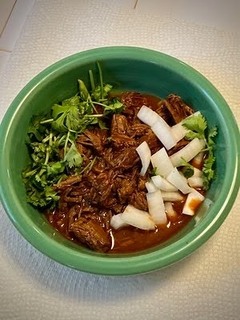 Spiced beef stew topped with cilantro and diced onions